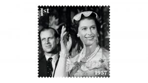Rainha Elizabeth II ao lado de seu marido, Philip. A foto é em preto em braco. Ela está sorrindo e acenando
