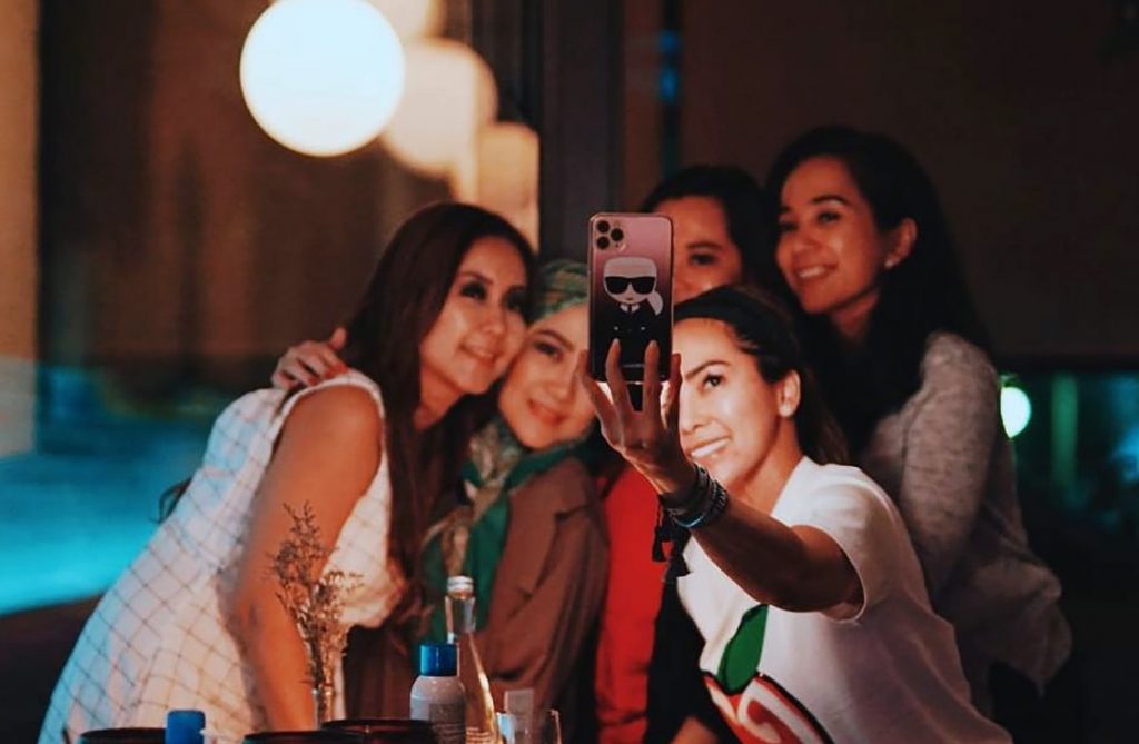Jovens fazem selfie em uma festa, e o excesso de fotos armazenadas é um dos inimigos de uma vida mais sustentável