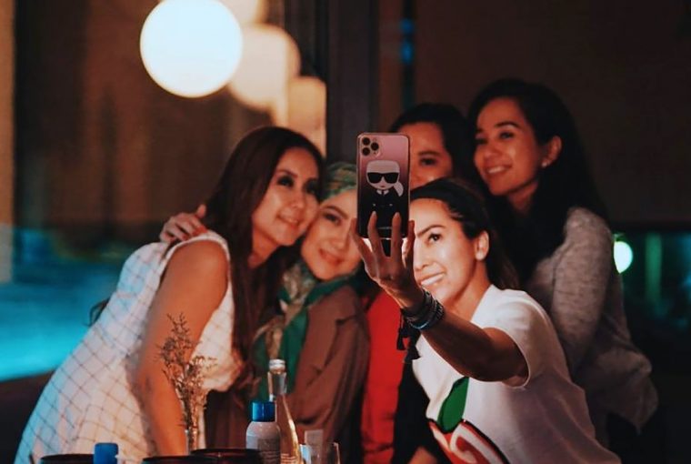 Jovens fazem selfie em uma festa, e o excesso de fotos armazenadas é um dos inimigos de uma vida mais sustentável