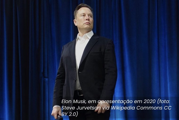 Elon Musk bilionário que comprou o Twitter de terno preto fundo azul briga com imprensa