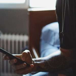 Homem usando smartphone violência doméstica online pesquisa governo britânico regulamentação redes sociais