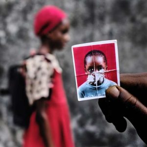 Foto menina de vestido vermelho e foto 3x4 é uma das finalistas do concurso fotografia africana contemporânea CAP Prize 2023