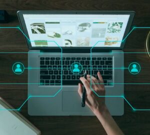 Pessoa digitando no computador e ícones de figuras humanas representa o uso da inteligência artificial generativa em comunicação
