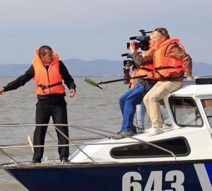 Cinegrafista filmando em um barco