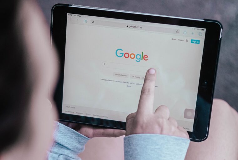 Homem com tablet apontando para tela de busca do Google, que implantou o recurso Privacy Sandbox