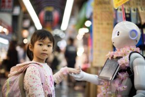 Menina cumprimenta robô alimentado por IA, tecnologia que vem sendo cada vez mais usada na educação