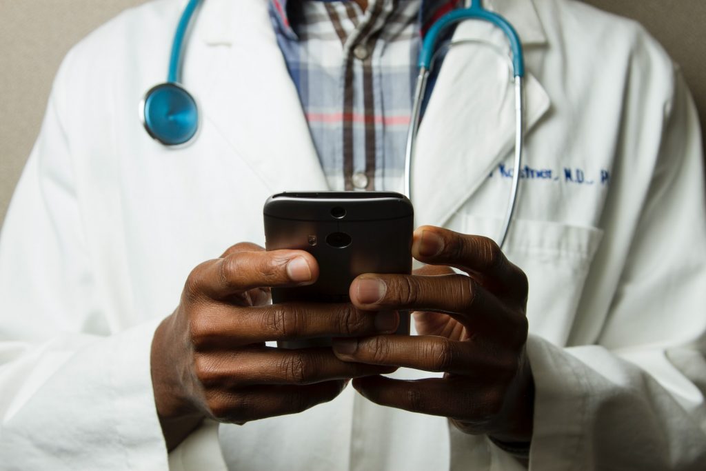 Médico de jaleco lendo smartphone Pulitzer desinformação científica negação ciência