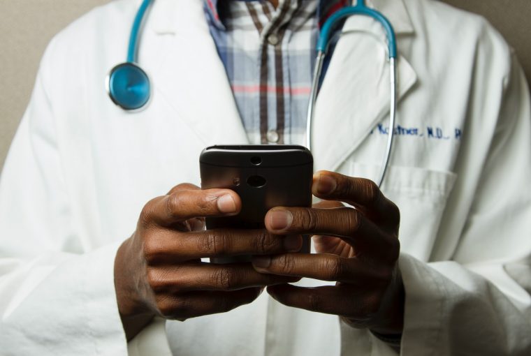 Médico de jaleco lendo smartphone Pulitzer desinformação científica negação ciência