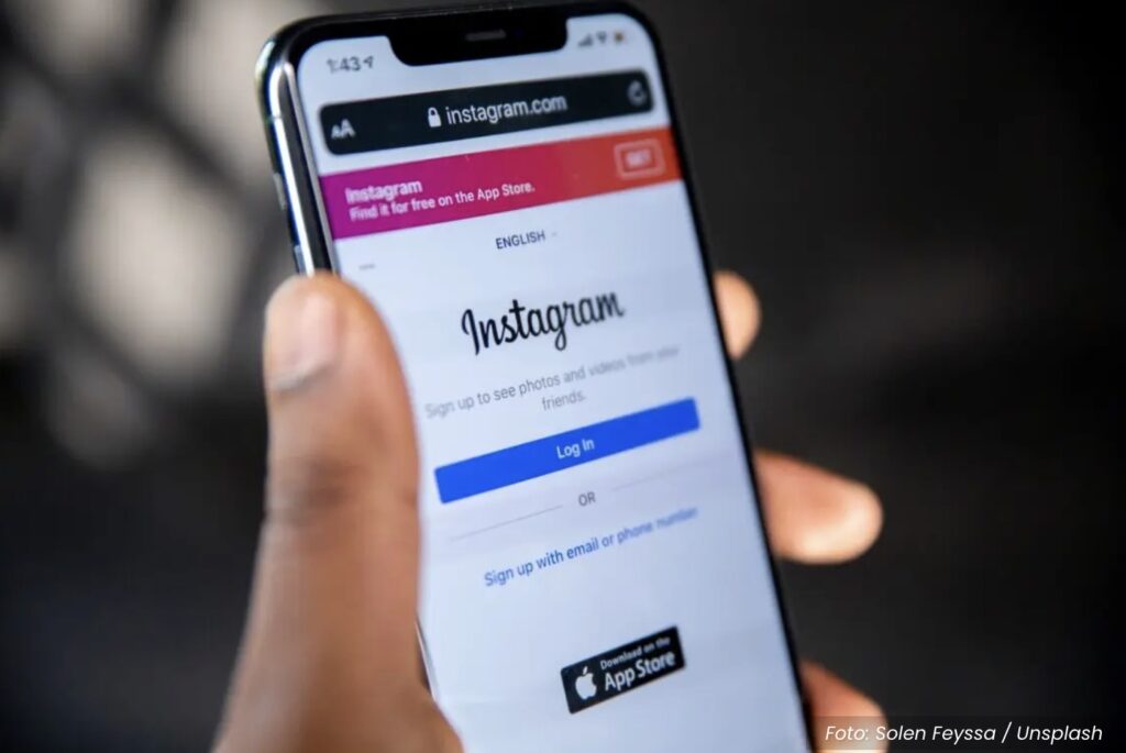 Pessoa segurando smartphone com tela Instagram, rede social da Meta