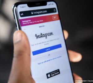 Pessoa segurando smartphone com tela Instagram, rede social da Meta