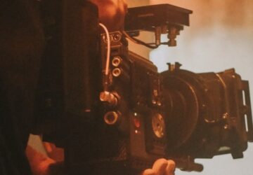 Cinegrafista filmando em cenário esfumaçado vermelho