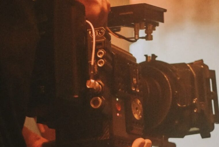 Cinegrafista filmando em cenário esfumaçado vermelho