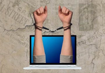 Criminalização jornalismo jornalista liberdade de imprensa computador mão algema