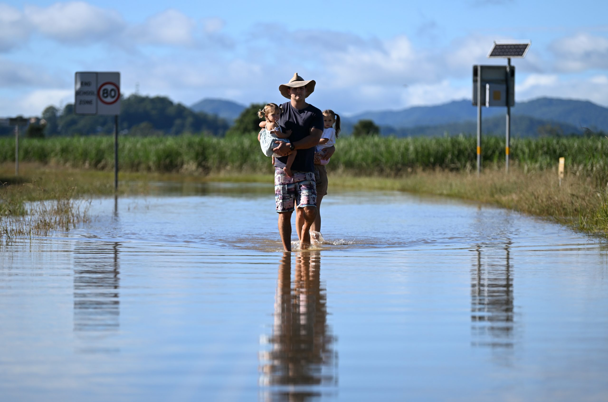 Mudança climática alagamento Austrália homem com criança no colo