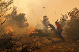 Homens apagando incêndio florestal em Atenas, Grécia