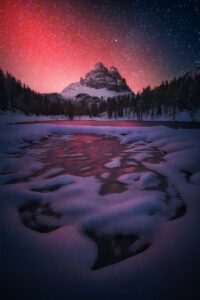 O registro foi feito nas Dolomitas, cadeias de montanhas na Itália e mostra a aurora boreal em tons de vermelho