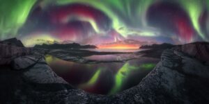 A imagem registra uma intensa aurora boreal na Ilha Senja, na Noruega