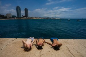 Crianças deitadas em cais em frente ao mar na Espanha