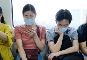 China muher com telefone no trem Ano Novo Chinês covid