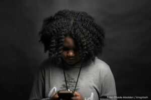 Jovem negra lendo no smartphone