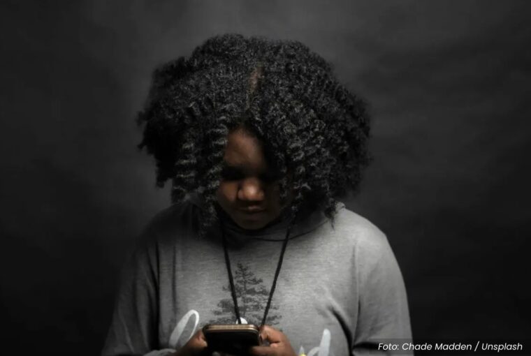 Jovem negra lendo no smartphone
