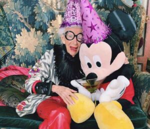 Iris Apfel com Mickey Mouse comemorando aniversário do personagem da Disney