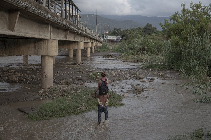 homem carrega mulher no rio Venezuela concurso prêmio fotografia fotojornalismo WPP