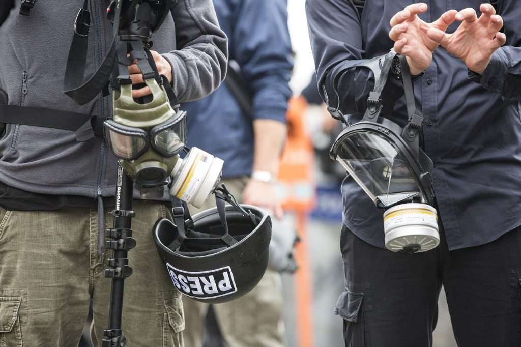 Jornalistas usando máscaras em zona de guerra um exemplo dos riscos a que estão expostos os profissionais de mídia, que celebram no dia 3 de maio o Dia Mundial da Liberdade de Imprensa