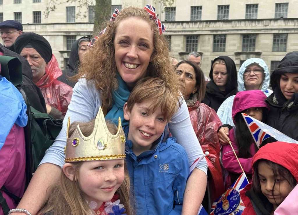 Mãe, filha e filho assistem à coroação do rei Charles III em Londres, composta por uma série de eventos destinados a engajar o público e consolidar a força da monarquia sob pressão por escândalos e protestos por democracia