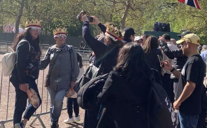 Mulheres com coroa e óculos com bandeira inglesa na coroação do rei Charles III em Londres em sinal de apoio à monarquia