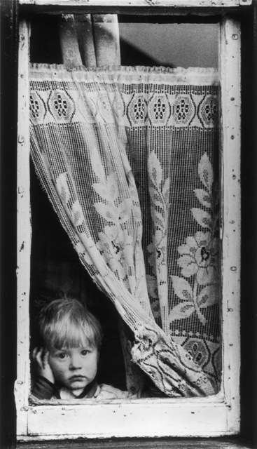 A imagem de um menino na janela é uma das que faz parte de uma exposição de mulheres na fotografia britânica realizada na feira Photo London 2023