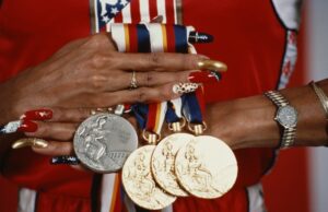 Florence Griffith-Joyner exibe suas medalhas e suas unhas pintadas com as cores dos EUA. Olimpíadas da Coreia 