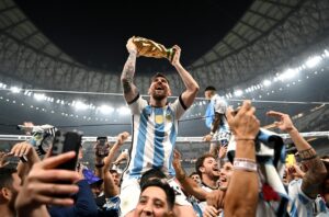 Leonel Messi comemora com o troféu da Copa do Mundo do Catar