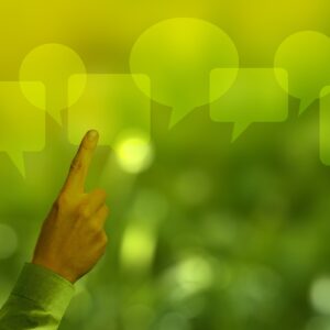 Mão apontando para balões de fala ilustra artigo sobre como a comunicação pode ajudar as empresas a engajar seus públicos em uma cadeia de valor sustentável alinhada aos valores ESG