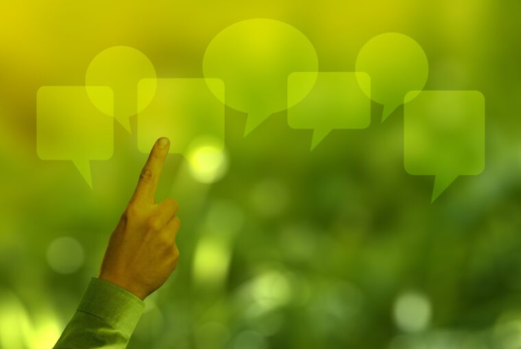 Mão apontando para balões de fala ilustra artigo sobre como a comunicação pode ajudar as empresas a engajar seus públicos em uma cadeia de valor sustentável alinhada aos valores ESG