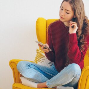 Mulher jovem sentada com telefone celular