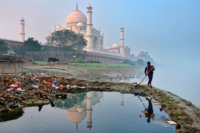 Taj Mahal ao fundo e homem limpando o aterro na ìndia. Imagem foi uma das finalistas do concurso de fotografia sobre meio ambiente EPOTY 2023