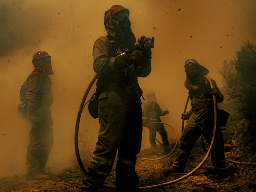 Bombeiros combatem um incêndio florestal na Espanha. A imagem é uma das finalistas do concurso de fotos de meio ambiente