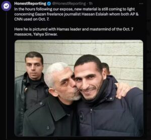 O fotojornalista palestino Hassan Eslayed que cobria a guerra em Gaza, aparece na foto sendo abraçado pelo líder do Hamas, Yahia Sinwar.