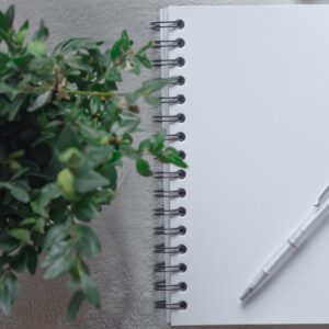 Caderno em branco com folhas verdes