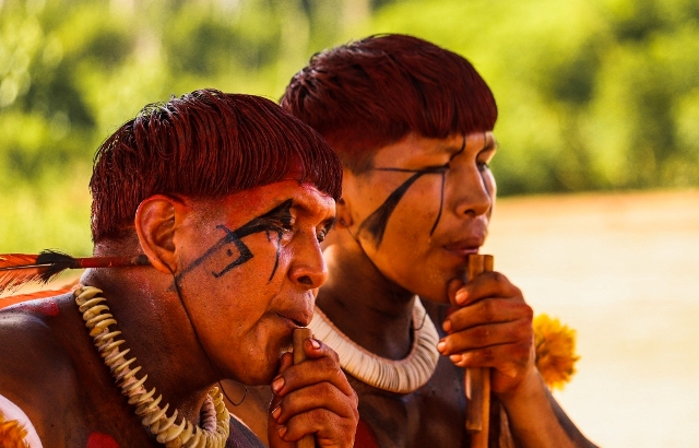 Índios da Aldeia Piyulaga tocando instrumento. Xingu, Mato Grosso