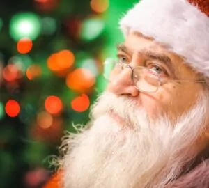 Papai Noel pensativo com árvore de Natal ao fundo