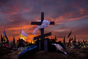 Cruz com um pano branco e os túmulos militares no cemitério de Kharkiv, Ucrânia. A imagem é uma das fotos de guerra 2023 da Getty Images