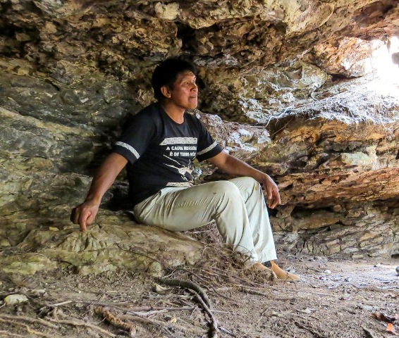 Índio sentado na caverna da Aldeia Piyulaga, Xingu, Mato Grosso