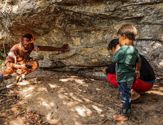 Índios observam a pedra da caverna que está sendo recuperada na Aldeia Piyulaga, Xingu, Mato Grosso