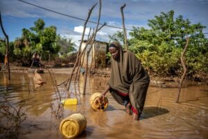 Morador do Quênia tenta recolher pertences em área inundada