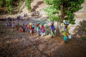 Mulheres carregam água na Índia devido a seca que atingiu a região. A imagem ilustra um dos eventos climáticos 2023