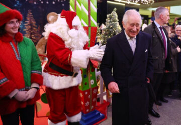 Rei Charles e Papai Noel em visita a mercado de Natal