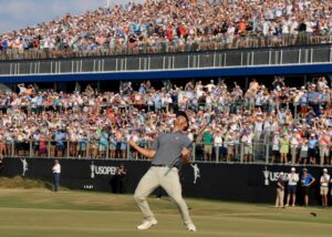 Homem comemora vitória em estádio. A imagem foi premiada na categoria golfe do prêmio de foto de esportes