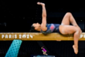 Ginasta fazendo exercício na barra. A imagem foi premiada no concurso de fotos esportivas